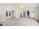 Spacious living room boasts soft carpeting, gray walls, and a seamless connection to the outdoors through French doors at 5590 Princeton Oaks Dr, Sugar Hill, GA 30518