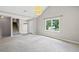 Bright living room featuring gray walls, plush carpeting, staircase, and abundant natural light at 5590 Princeton Oaks Dr, Sugar Hill, GA 30518