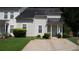 Traditional two-story townhouse with beige siding, dark roof, front lawn and paved driveway at 6460 Wellington Chase Ct, Lithonia, GA 30058