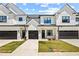 Modern townhome exterior with white siding, black accents, and individual garages at 208 Starr Cir, Stockbridge, GA 30281