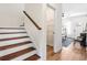 Open staircase with wood treads, white risers, and a view into the living area at 208 Starr Cir, Stockbridge, GA 30281