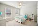 Cozy bedroom with natural light, neutral walls, a ceiling fan, and a neatly arranged bed at 3915 Northridge Dr, Cumming, GA 30040