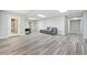 Finished basement with gray wood-look flooring, a seating area, and a walkout door at 420 Big Bend Trl, Sugar Hill, GA 30518