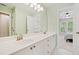 Bright bathroom featuring dual sinks, white cabinets, and serene views into the Primary bedroom at 420 Big Bend Trl, Sugar Hill, GA 30518