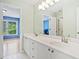 A bright and inviting bathroom with white cabinets and double sinks, leading into a vibrant blue bedroom at 420 Big Bend Trl, Sugar Hill, GA 30518