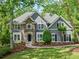 Charming home with a stone accent exterior, manicured lawn, and mature trees at 420 Big Bend Trl, Sugar Hill, GA 30518