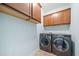 Convenient laundry room with modern washer and dryer units and overhead storage at 420 Big Bend Trl, Sugar Hill, GA 30518
