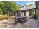 Backyard patio with an outdoor table, lush trees, and a screened-in porch for entertaining at 4531 Kings Lake Dr, Marietta, GA 30067