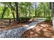 Landscaped backyard featuring a winding gravel path, lush greenery, and mature trees, creating a serene outdoor space at 4531 Kings Lake Dr, Marietta, GA 30067