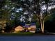 Charming home nestled among mature trees with a well-maintained lawn and inviting facade at twilight at 4531 Kings Lake Dr, Marietta, GA 30067