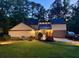 Well-lit exterior of the home at night with a landscaped yard, modern design, and inviting ambiance at 4531 Kings Lake Dr, Marietta, GA 30067