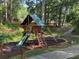 Wooden playground nestled among mature trees with mulch bed, slide and climbing area at 4531 Kings Lake Dr, Marietta, GA 30067