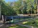 A community tennis court surrounded by a dark fence and mature trees at 4531 Kings Lake Dr, Marietta, GA 30067