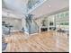 Bright open-concept living space with hardwood floors, a staircase, and a glass railing at 7504 Rivertown Rd, Fairburn, GA 30213