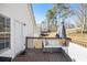 Back deck with outdoor seating and view to the level yard and surrounding trees at 7760 Poppy Dr, Winston, GA 30187