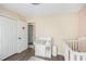 Bedroom with crib, changing table, and view to open closet with natural light at 7760 Poppy Dr, Winston, GA 30187