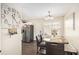Dining area with a large clock on the wall, modern chandelier, and stainless refrigerator at 7760 Poppy Dr, Winston, GA 30187