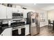 Modern kitchen featuring stainless steel appliances, black countertops, and white cabinets at 7760 Poppy Dr, Winston, GA 30187