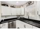 Sleek kitchen with black countertops, stainless steel appliances, modern backsplash, and white cabinets at 7760 Poppy Dr, Winston, GA 30187