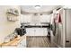 Modern kitchen features white cabinetry, stainless steel appliances, black countertops and wood-look flooring at 7760 Poppy Dr, Winston, GA 30187