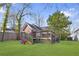 Large backyard with vibrant green lawn and a quaint red outbuilding featuring a wooden deck and staircase at 1081 Longley Nw Ave, Atlanta, GA 30318
