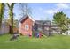 Backyard features a spacious lawn and charming red outbuilding with a wooden deck, perfect for outdoor enjoyment at 1081 Longley Nw Ave, Atlanta, GA 30318