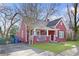 Charming red home features a covered porch, green lawn, and classic architectural details at 1081 Longley Nw Ave, Atlanta, GA 30318