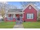 Charming red home features a covered porch, green lawn, and classic architectural details at 1081 Longley Nw Ave, Atlanta, GA 30318