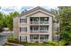 Multi-story condo exterior featuring private balconies and manicured landscaping, framed by green trees at 1250 Parkwood Se Cir # 1203, Atlanta, GA 30339