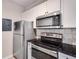 Efficient kitchen featuring stainless steel appliances, granite countertops, and sleek white cabinets for a modern touch at 1250 Parkwood Se Cir # 1203, Atlanta, GA 30339