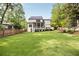 Expansive backyard featuring a lush lawn, screened porch, back deck, and mature trees offering privacy at 304 Meadowbrook Ne Dr, Atlanta, GA 30342