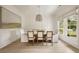Formal dining room with wainscoting, modern chandelier, large window, and a stylish dining set at 304 Meadowbrook Ne Dr, Atlanta, GA 30342