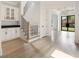 Bright foyer with beautiful staircase, custom cabinetry, light wood floors and modern chandelier at 304 Meadowbrook Ne Dr, Atlanta, GA 30342