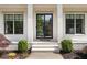 Elegant front door with black trim flanked by windows and manicured landscaping, enhancing curb appeal at 304 Meadowbrook Ne Dr, Atlanta, GA 30342