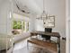 Stylish home office with a rustic desk, leather bench, decorative chandelier, and large bright window at 304 Meadowbrook Ne Dr, Atlanta, GA 30342