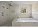 Luxurious bathroom with a soaking tub, a frameless shower with multiple shower heads and marble finishes at 304 Meadowbrook Ne Dr, Atlanta, GA 30342