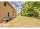 Side view of large backyard featuring green grass and mature trees with siding of home in view at 3912 Margaux Dr, Atlanta, GA 30349