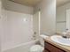 Bright bathroom with a white shower-tub combo, toilet, and vanity with modern fixtures at 3912 Margaux Dr, Atlanta, GA 30349