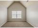 This bedroom features a vaulted ceiling, neutral paint, and a window with natural light at 3912 Margaux Dr, Atlanta, GA 30349