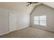 This bedroom features neutral paint, vaulted ceiling, and a window with natural light, and door at 3912 Margaux Dr, Atlanta, GA 30349
