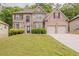 Charming two-story brick home with a well-manicured lawn and attached two-car garage at 3912 Margaux Dr, Atlanta, GA 30349