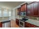 View of kitchen with stainless steel appliances, granite countertops and dark wood cabinets at 3912 Margaux Dr, Atlanta, GA 30349