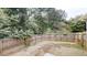 View of a fully fenced backyard with mature trees providing shade and privacy at 5246 Salem Springs Pl, Lithonia, GA 30038