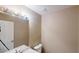 Neutral-toned bathroom features modern lighting fixture and white porcelain sink and toilet at 5246 Salem Springs Pl, Lithonia, GA 30038