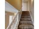 Carpeted staircase with white handrail leads to the upper level of the home at 5246 Salem Springs Pl, Lithonia, GA 30038