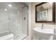 A bathroom features a stand up shower with glass door and a white sink with vanity at 825 Yosemite Dr, Suwanee, GA 30024