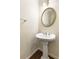 Powder room features a pedestal sink, decorative mirror, and modern fixtures at 825 Yosemite Dr, Suwanee, GA 30024