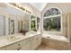 Bright bathroom features a double vanity, soaking tub, and large windows with backyard views at 825 Yosemite Dr, Suwanee, GA 30024