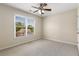 An empty bedroom with neutral walls and plush carpet and a window overlooking the neighborhood at 825 Yosemite Dr, Suwanee, GA 30024