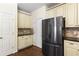 Kitchen with stainless steel fridge, granite countertops, and cream-colored cabinetry at 825 Yosemite Dr, Suwanee, GA 30024